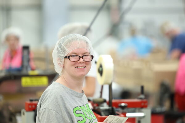 Young woman with disabilities working in packaging plant