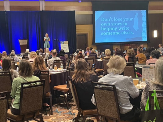 Keynote speaker addresses large ballroom of people