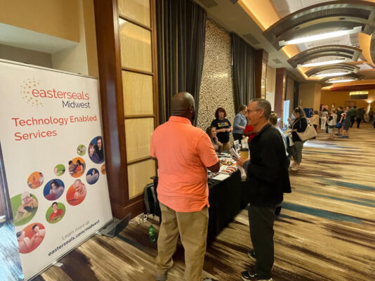 Staff from Easter Seals speak with conference participants