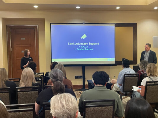 Presenter addressing room of conference participants
