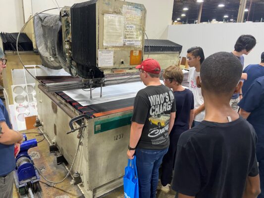 High schoolers with disabilities watch manufacturing equipment during BCI's SparkForce Summer Camp