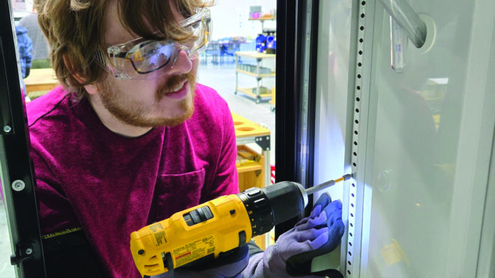 Young man using drill during BCI vocational training